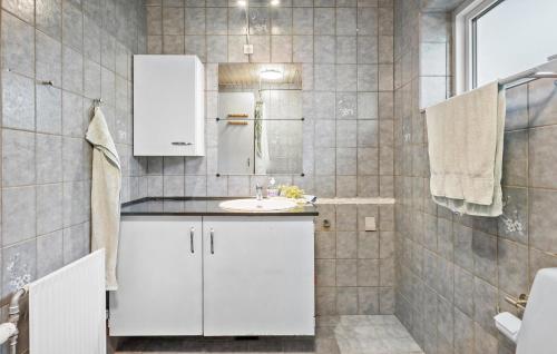 a white bathroom with a sink and a mirror at Lovely Home In Vemb With House Sea View in Vemb