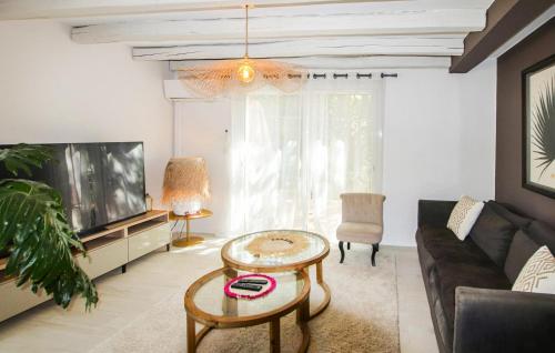 un salon avec un canapé, une table et une télévision dans l'établissement Awesome Home In Rochefort Du Gard, à Rochefort-du-Gard