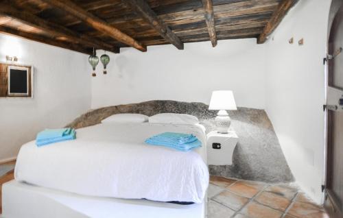 a white bedroom with a white bed and a lamp at Nice Home In Orgosolo With Wifi in Orgosolo