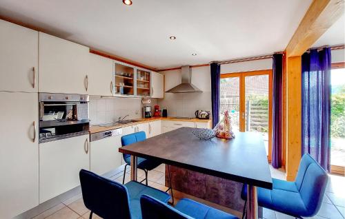 a kitchen with a table and some blue chairs at Amazing Home In Rupt-Sur-Moselle in Rupt-sur-Moselle