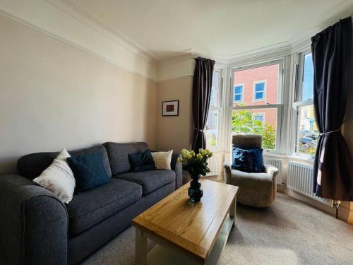 a living room with a couch and a table at Totterdown House with Views & Garden in Bristol