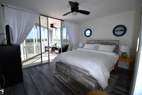 サラソタにあるPrivate Beach Condo On Lido Keyの大きなベッドとバルコニーのある寝室