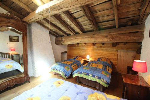 a bedroom with two beds and a wooden ceiling at La Belle Bergerie in Saint-Bonnet-de-Bellac