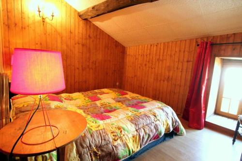 a bedroom with a bed and a table with a lamp at La Belle Bergerie in Saint-Bonnet-de-Bellac