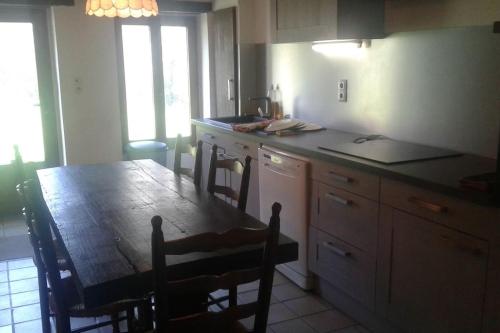a kitchen with a table and a table and chairs at La Belle Bergerie in Saint-Bonnet-de-Bellac