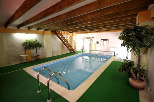 a large swimming pool with a green floor at La Belle Bergerie in Saint-Bonnet-de-Bellac