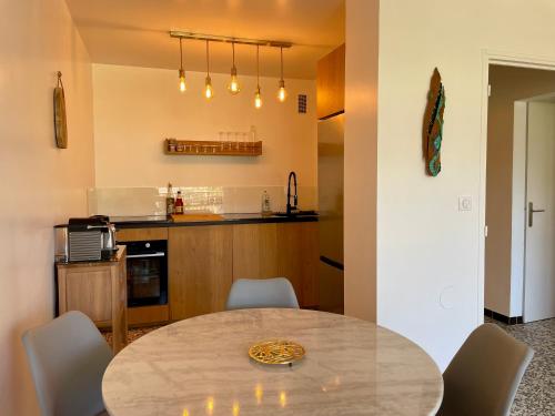 - une cuisine avec une table, des chaises et un comptoir dans l'établissement T3 à 300m plage avec piscine tennis, au Lavandou