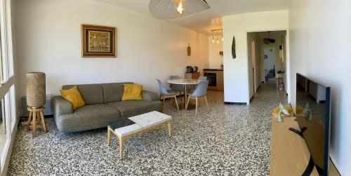 un salon avec un canapé et une table dans l'établissement T3 à 300m plage avec piscine tennis, au Lavandou