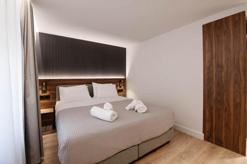 a bedroom with a bed with two towels on it at Kantoni Suites in Corfu Town