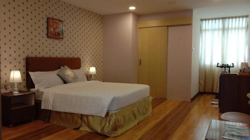 a bedroom with a large bed and a window at Coconut Bay Lodge - Beribi in Bandar Seri Begawan