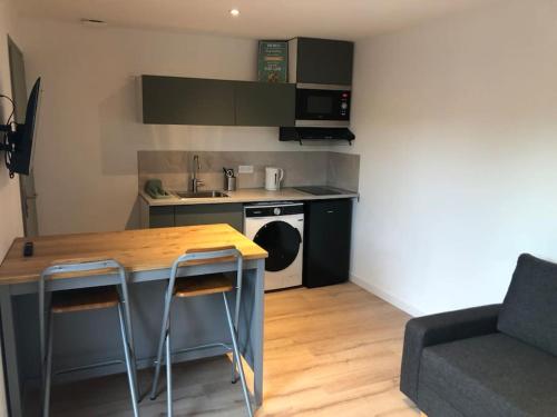 a small kitchen with a table and a stove at Appartement Cosy-Grand Stade Villeneuve d'Ascq in Lezennes