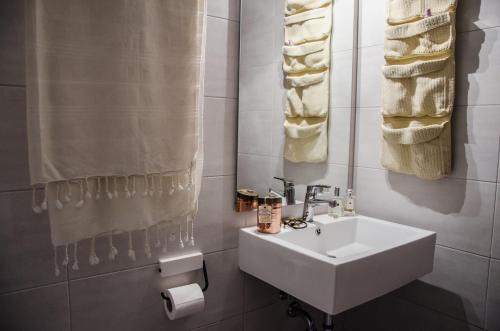 a white bathroom with a sink and towels at Villa Anna in Megali Ammos