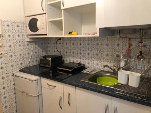 une cuisine avec un évier et un micro-ondes dans l'établissement Studio vue montagne et soleil, à Amélie-les-Bains-Palalda