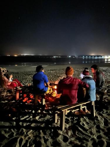 a group of people sitting on a beach at night at Casa Tarantini in Lobitos