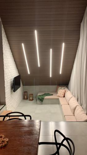 a living room with a couch and a table and lights at Chalés Piribless-Ikigai in Pirenópolis