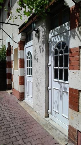 un bâtiment avec des portes blanches et un trottoir en briques dans l'établissement Le Domaine, à Moustey