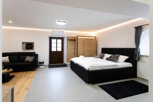 a bedroom with a bed and a living room at Wellba Homestead Planina in Ajdovščina