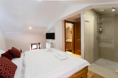a bedroom with a large white bed and a shower at Wellba Homestead Planina in Ajdovščina