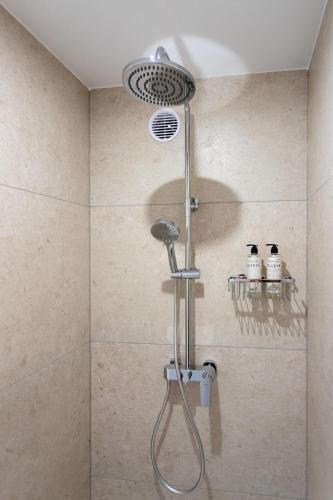 a shower with a shower head in a bathroom at Wellba Homestead Planina in Ajdovščina