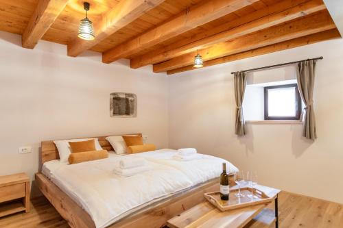 a bedroom with a large bed and a table at Wellba Homestead Planina in Ajdovščina