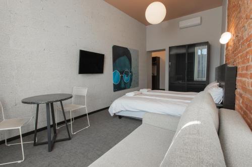 a bedroom with a bed and a table and a couch at Resume apartments in Kaunas