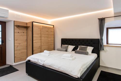 a bedroom with a large bed with white sheets at Wellba Homestead Planina in Ajdovščina