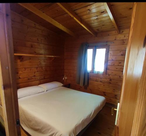 a bedroom with a bed in a wooden cabin at Camping La Vall d'Hostoles in Sant Feliu de Pallerols