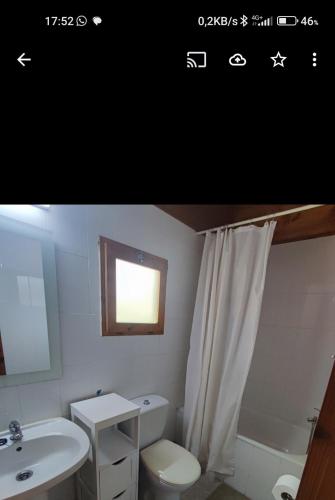 a bathroom with a sink and a toilet and a window at Camping La Vall d'Hostoles in Sant Feliu de Pallerols