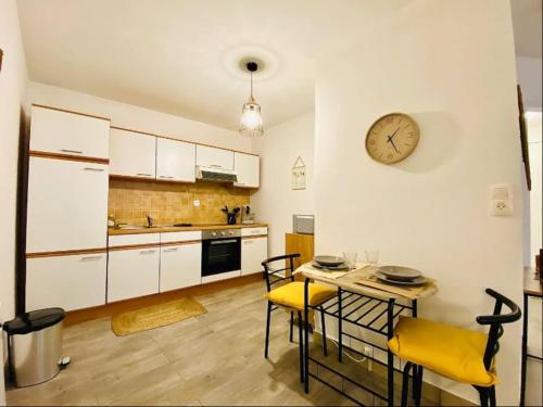 une cuisine avec une table et des chaises et une horloge au mur dans l'établissement Appartement Centre-Ville - 3 Voyageurs, au Mans