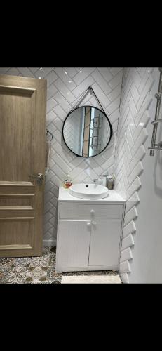 a bathroom with a white sink and a mirror at Уютный домик в Боровом in Borovoye