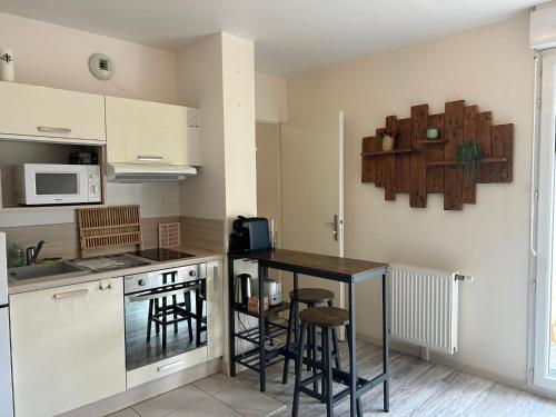 une cuisine avec une table et quelques chaises dans l'établissement Studio cosy proche Disneyland, à Ozoir-la-Ferrière