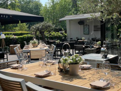 a table with glasses and napkins on a patio at Hotel Restaurant Het Witte Paard in Delden