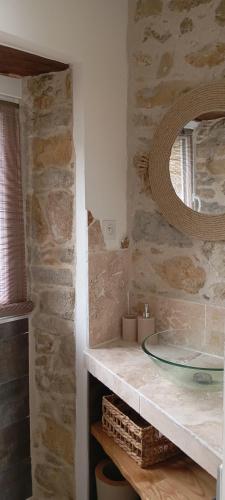 La salle de bains en pierre est pourvue d'un lavabo et d'un miroir. dans l'établissement A casettuccia santu petru, à Santo-Pietro-di-Venaco