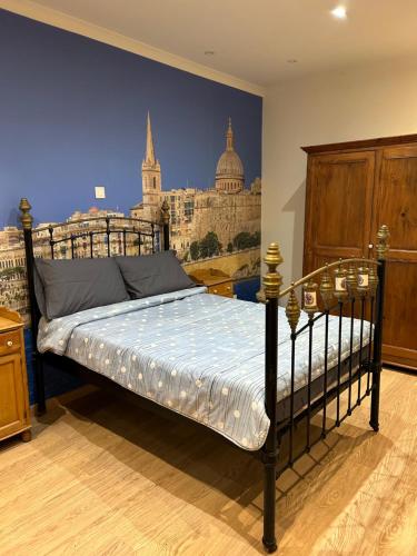 a bedroom with a bed with a painting of a city at Valletta cozy room in Valletta