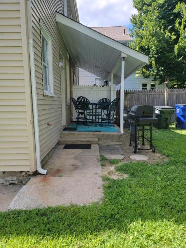 a patio with a table and chairs and a grill at 1895 meets 2023 Townhouse. in Hamilton