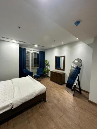 a bedroom with a bed and a tv and chairs at Penta Square Apartments in Lahore