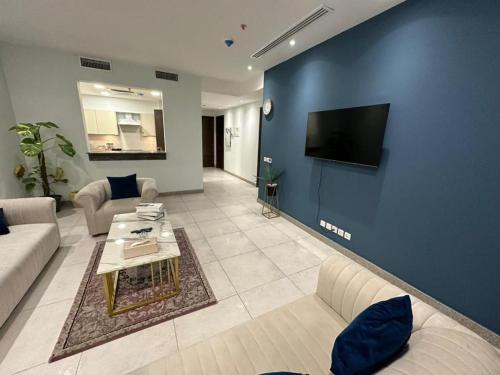 a living room with a couch and a tv on a blue wall at Penta Square Apartments in Lahore