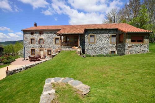a large stone house with a large yard at Le clos des pierres rouges in Saint-Privat-dʼAllier