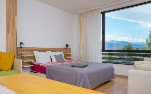 a bedroom with two beds and a large window at Aspen studio Mountain retreat at Aspen Resort Golf Ski & Spa in Razlog