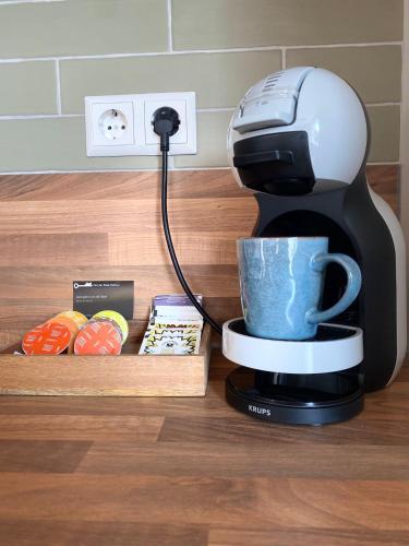 a coffee maker with a cup on a counter at Morning Glory, huisje Forest in Beekbergen