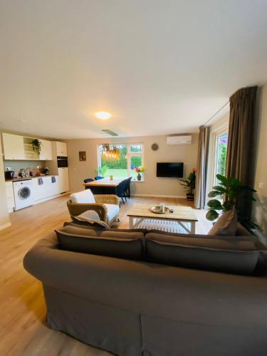 a living room with two couches and a living room with at Morning Glory, huisje Forest in Beekbergen
