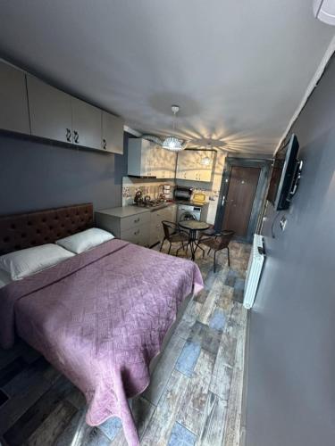 a bedroom with a bed and a kitchen with a table at Apartment- GURO in Batumi