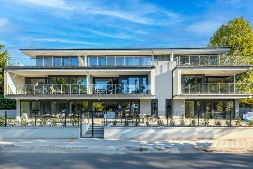 an apartment building with balconies and tables at H55 in Balatonlelle