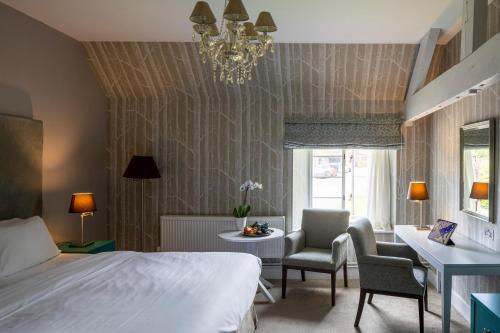 a bedroom with a bed and a table and chairs at The Wood Norton in Evesham