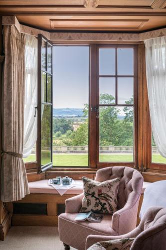 a room with a chair and a large window at The Wood Norton in Evesham