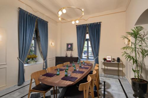 a dining room with a long table and blue drapes at Rephael House Boutique Hotel in Rishon LeẔiyyon