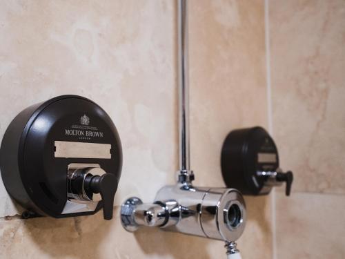 a toilet paper dispenser on the wall of a bathroom at The Wood Norton in Evesham