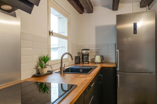 une cuisine avec un évier et un réfrigérateur dans l'établissement Appartement tout confort Vieux Tours avec parking privé 4p, à Tours