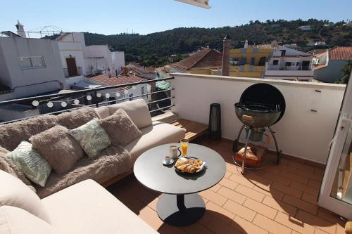 a living room with a couch and a table on a balcony at Casa Portao da Cidade in Silves