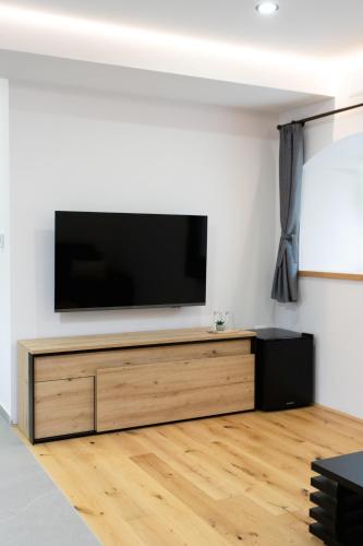 a flat screen tv sitting on top of a wooden entertainment center at Wellba Homestead Planina in Ajdovščina